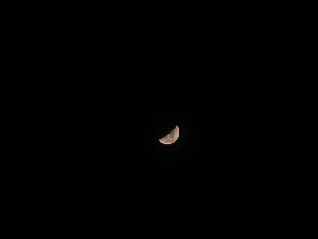 Luna en fase creciente fina recortada sobre un cielo nocturno azul oscuro y despejado