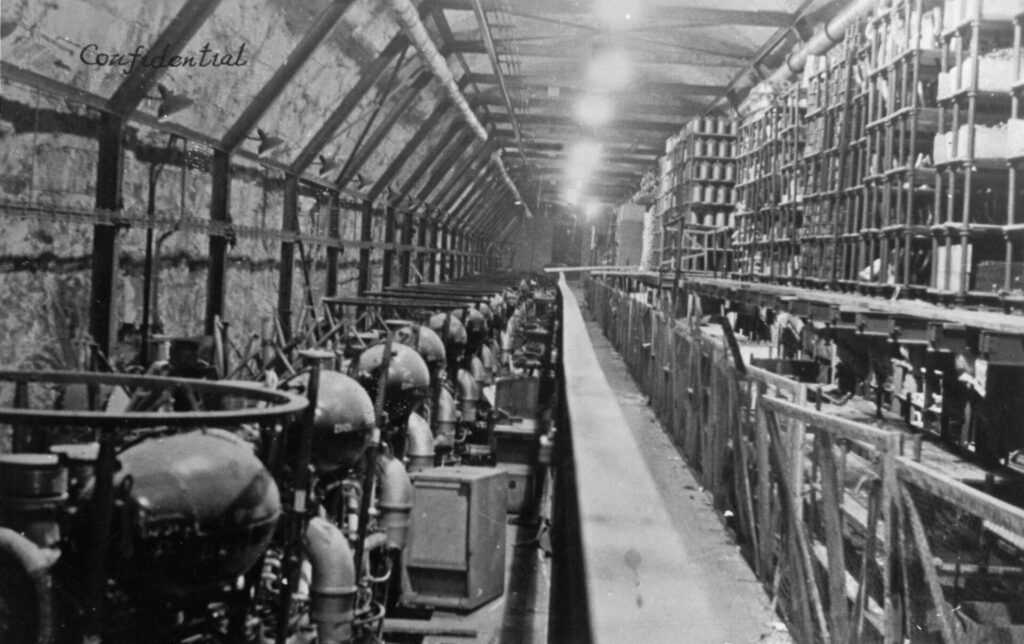 Nave industrial con secciones cilíndricas de cohete en montaje y andamios alrededor