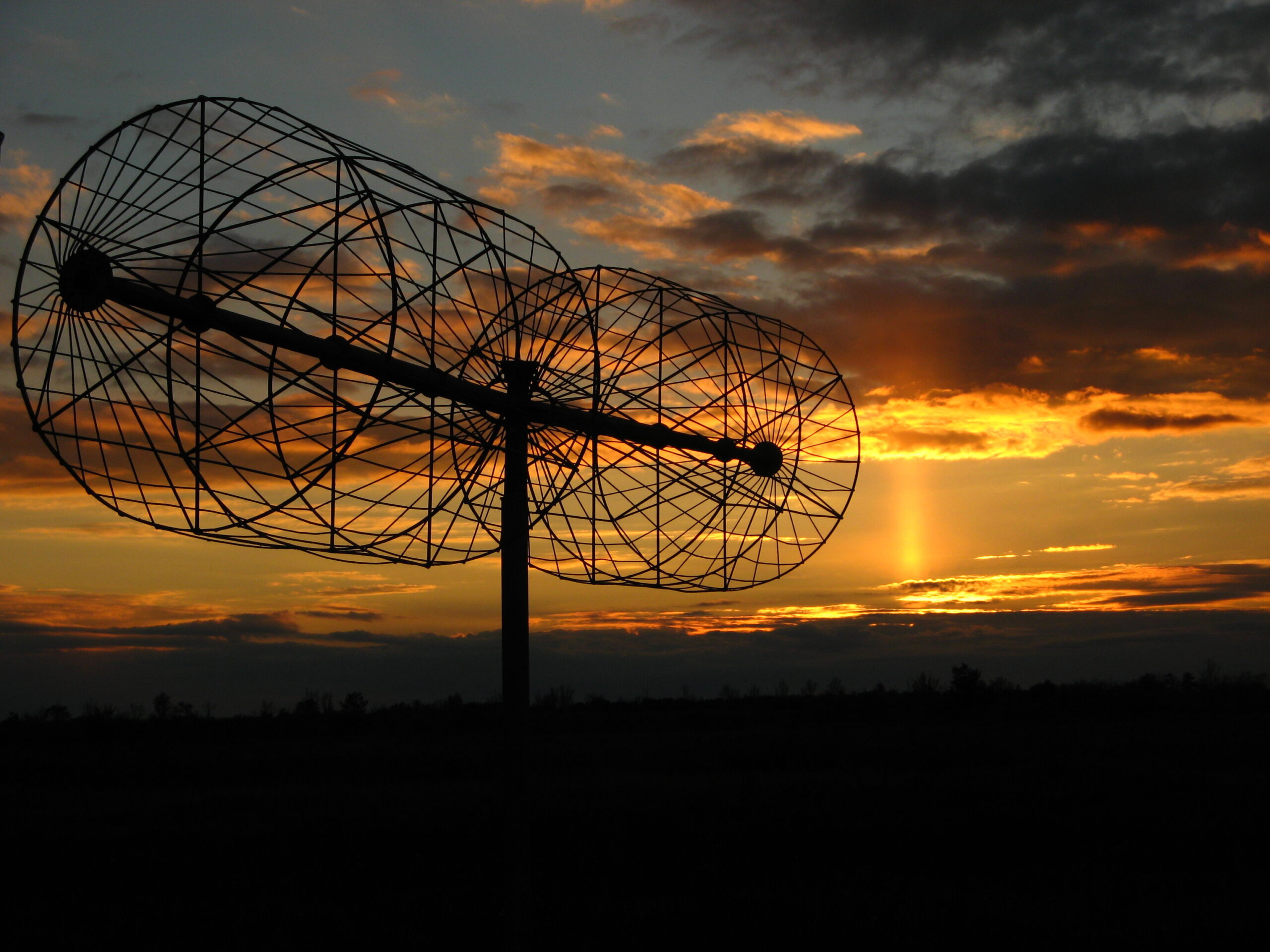 Hilera de antenas parabólicas idénticas apuntando al mismo punto del cielo en una llanura despejada