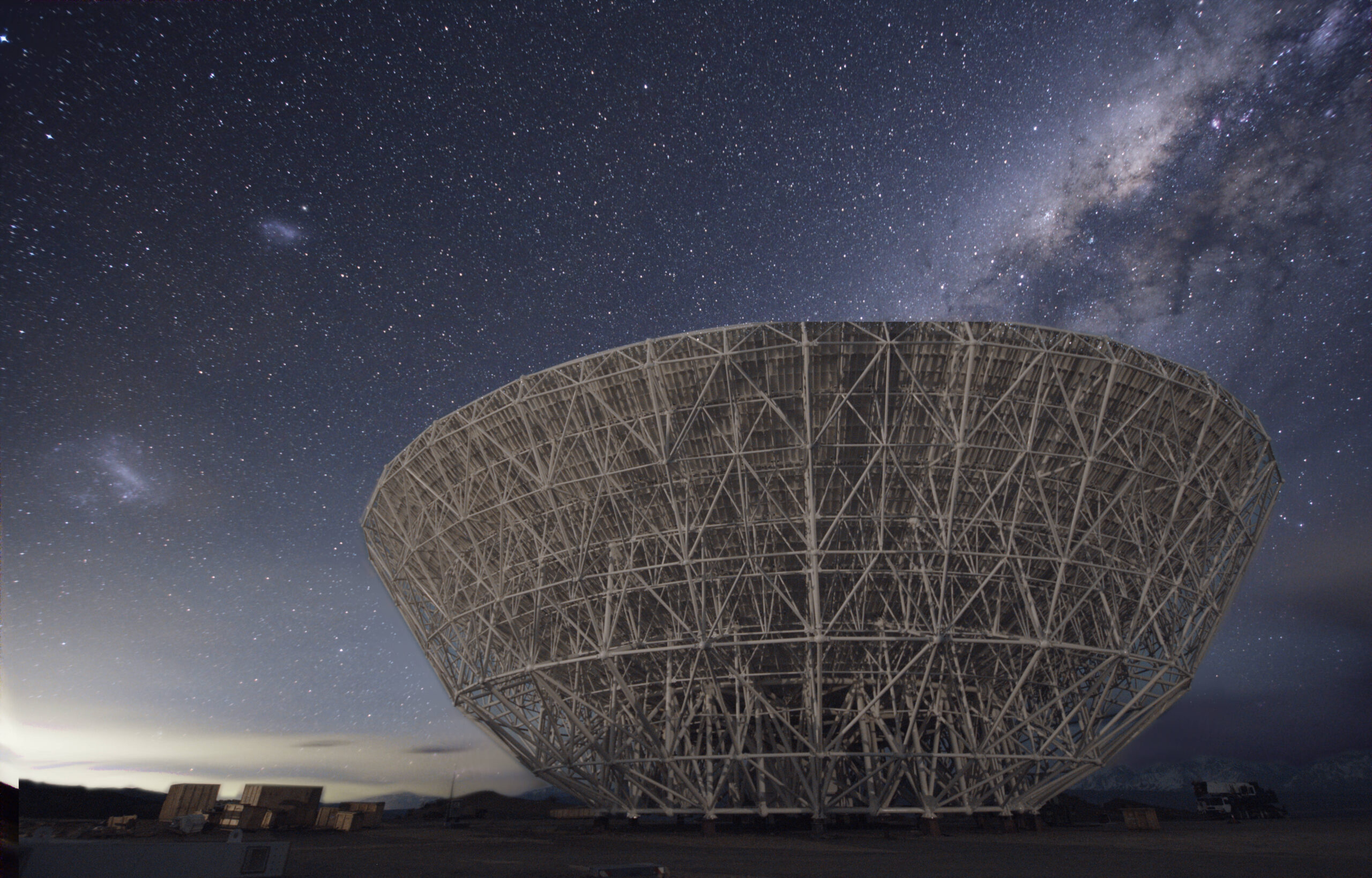 Antena parabólica de radiotelescopio recortada contra el cielo, con su estructura de soporte y el receptor central